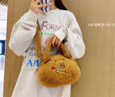 Fluffy Capybara Crossbody Purse! This kawaii bag resembling the body of the beloved capybara will earn you admiring glances wherever you go. The design features an embroidered capybara with a cheerful expression, holding out a flower—purely irresistible cuteness!